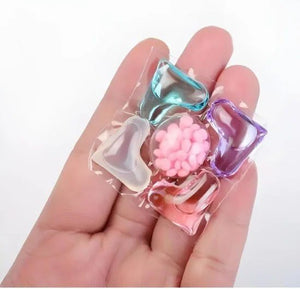 Colorful gelatin dessert with pink flower and candies held in a hand on a white background