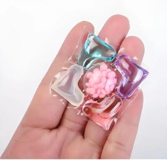 Colorful gelatin dessert with pink flower and candies held in a hand on a white background