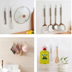 Set of kitchen utensils hanging on a wall with a potted plant and cleaning supplies.